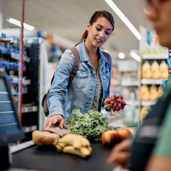 Female supermarket customer paying for goods at the checkout.